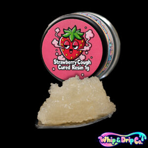 “Whip & Drip Co. Strawberry Cough cured resin concentrate with pale golden extract displayed beside strawberry-themed 1 gram product packaging on a black background.”